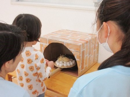 子供がピザ窯にピザをいれている様子